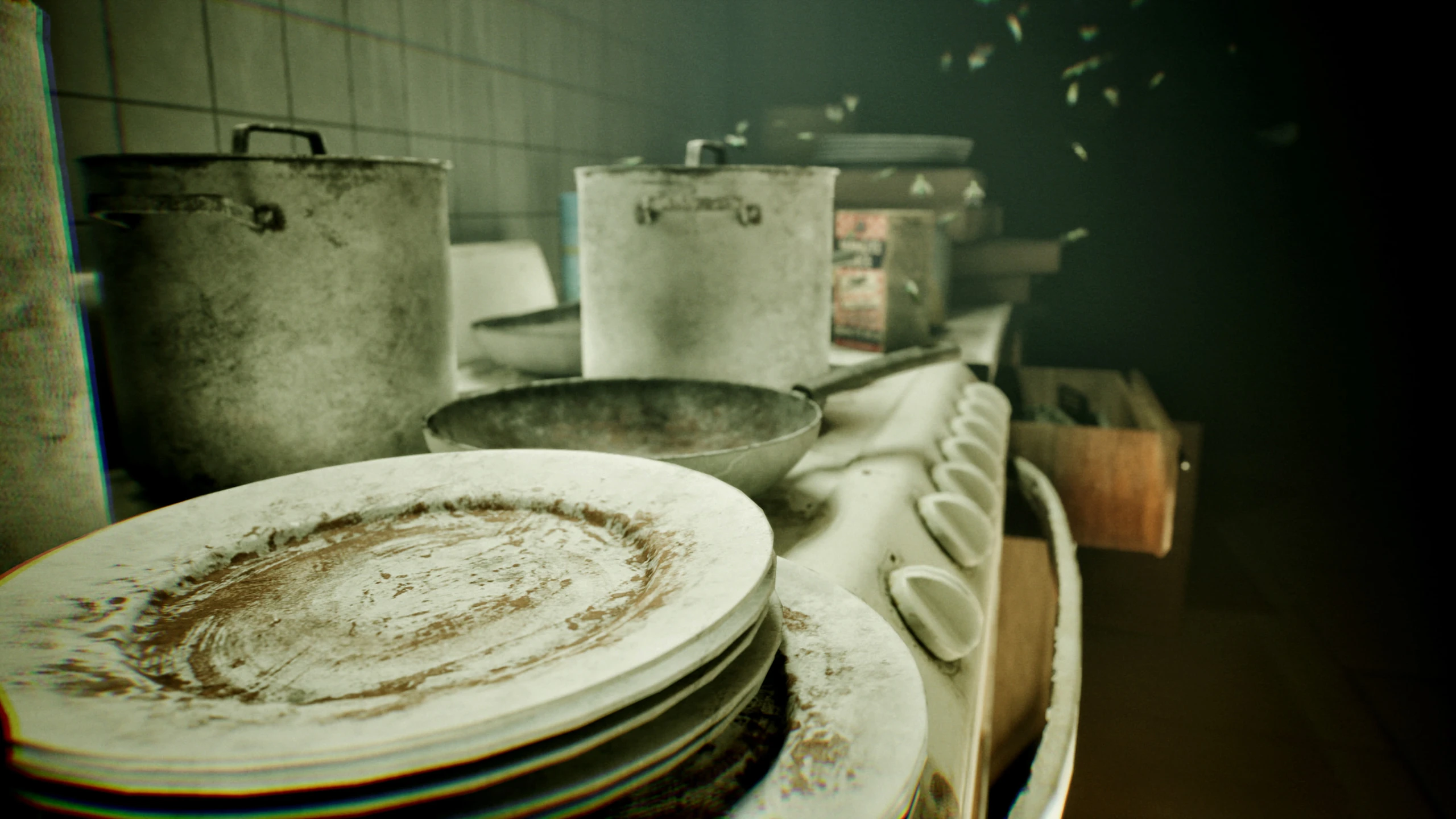 Close up of a grimy stove top, a stack of dirty plates in front of dented pots and a frying pan, with flies in the air above