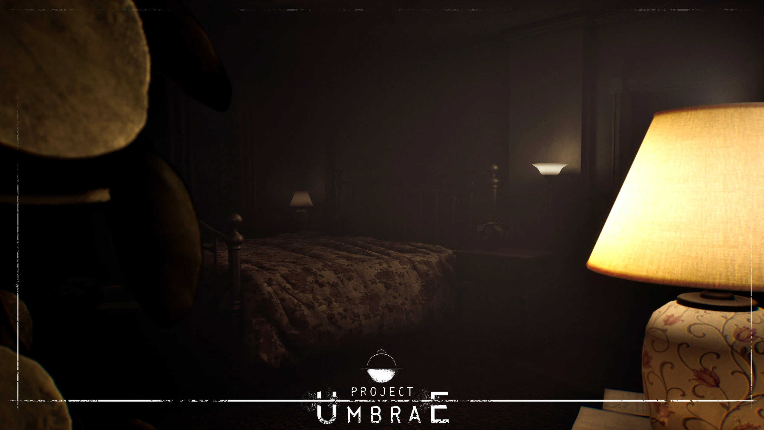 A bedside lamp with a floral ceramic base glowing in the foreground of a dark bedroom, a patterned quilt on the bed behind it, with the Project UMBRAE logo overlaid at the bottom