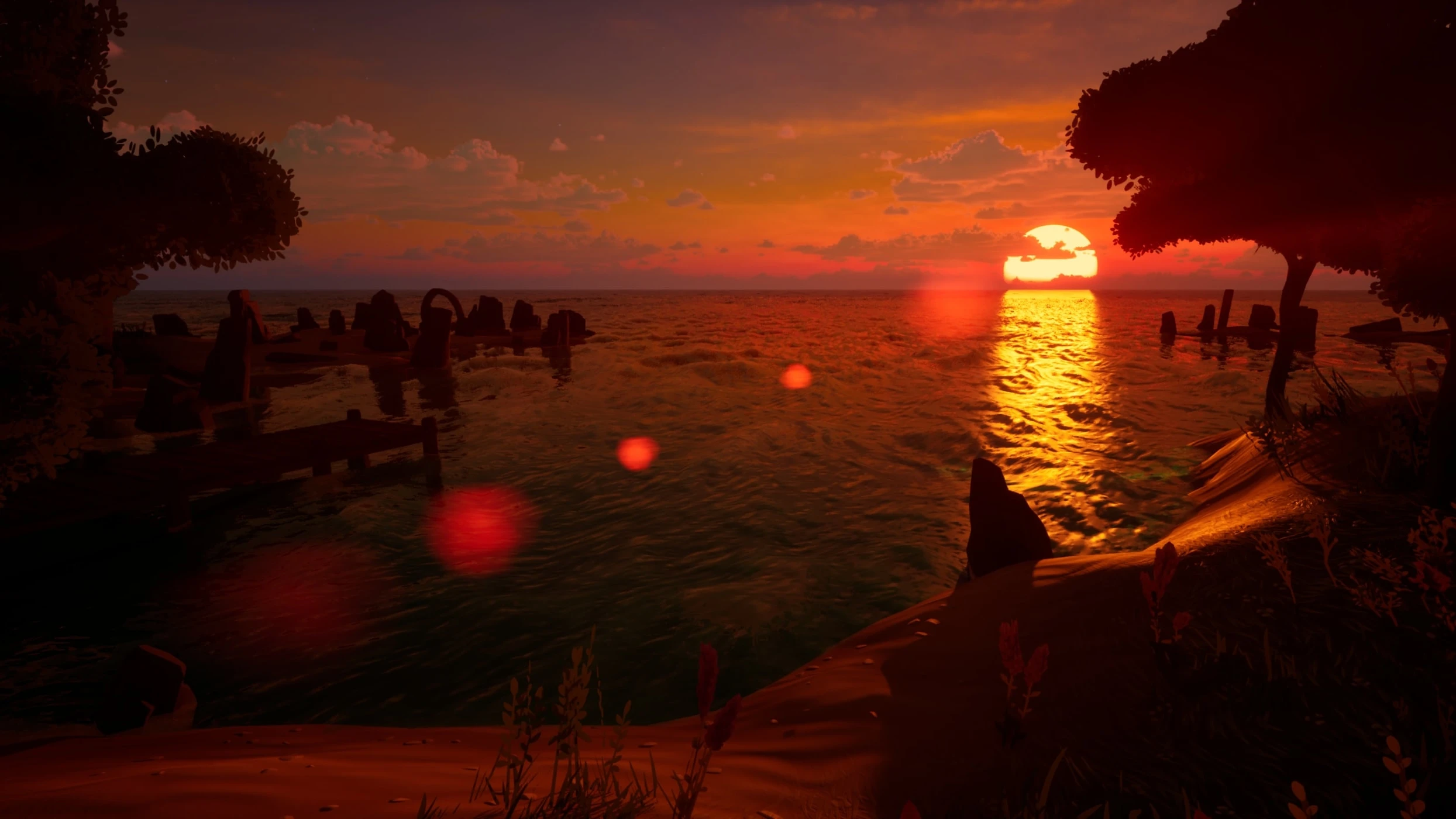 The ocean at sunset from the beach, the sun low on the horizon reflecting in a bright streak across the waves, with ruins and a jetty silhouetted in the water